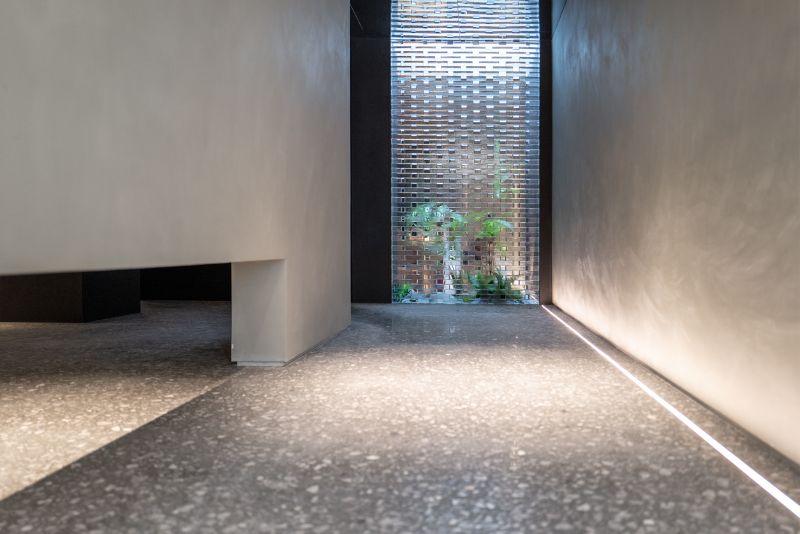 Hallway with glossy polished dark concrete floor and a feature window