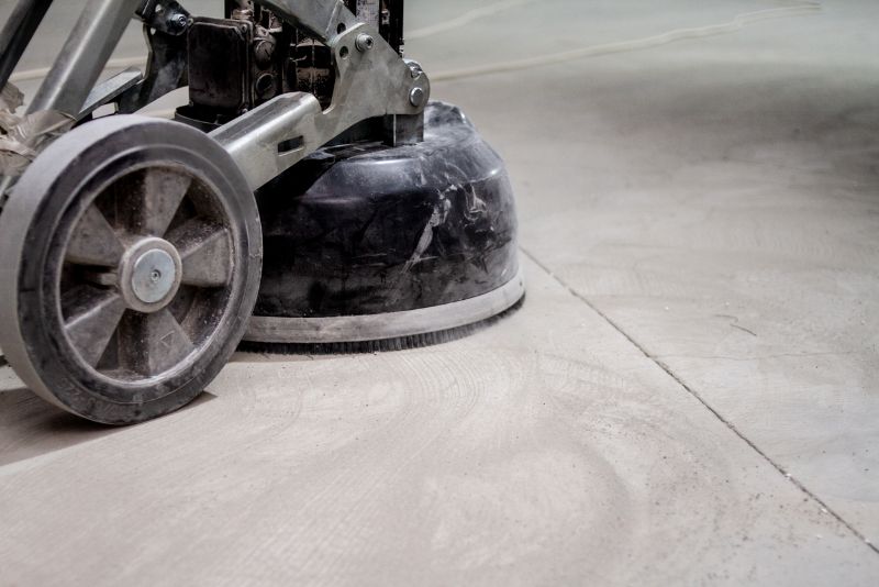 Close-up of a concrete floor grinder's polishing pad in use on a bare slab