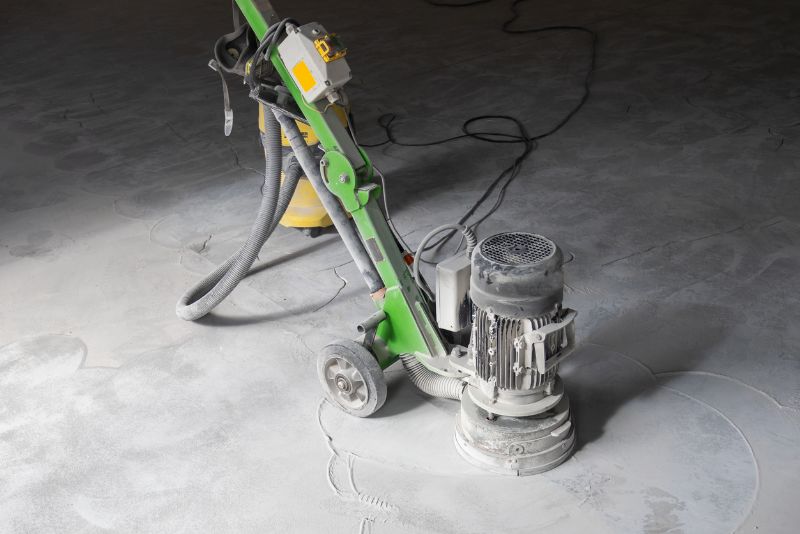 Concrete edging grinder positioned on a grey concrete floor with power cables