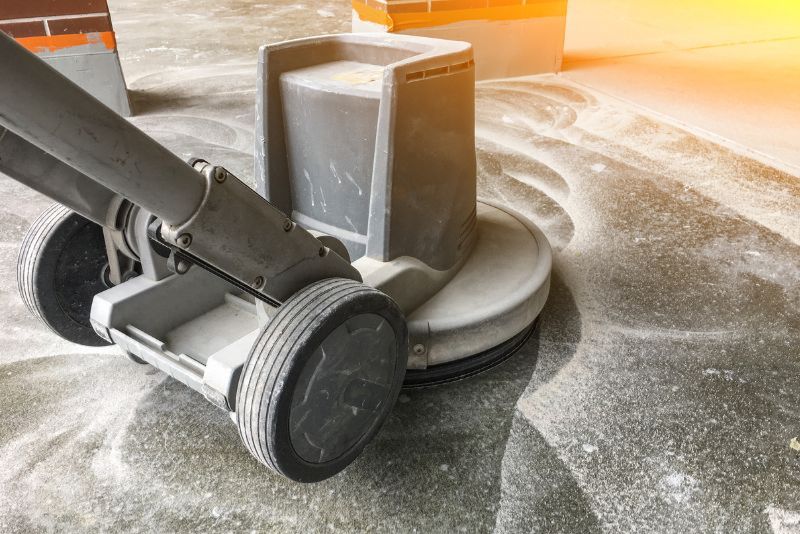 Concrete floor grinder polishing pad in use near a brick pillar