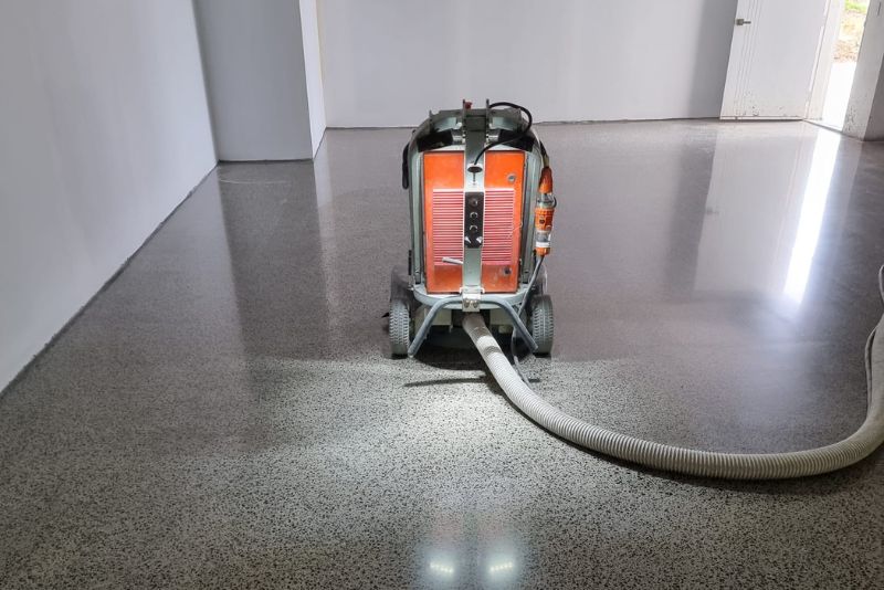 Walk-behind polisher finishing a glossy grey polished concrete floor