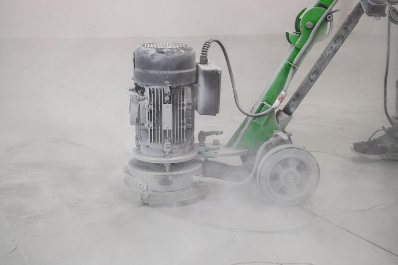 Concrete grinder in operation, floor surrounded by dust during the grinding process